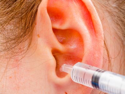 infirmière vérifiant la température du patient dans l'oreille avec